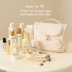Milky white vanity bag with quilted top, front zip pocket, and carrying handle
