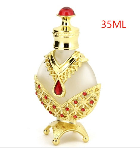 Perfume oil vial with red cap and teardrop emblem, white body, gold base and gems