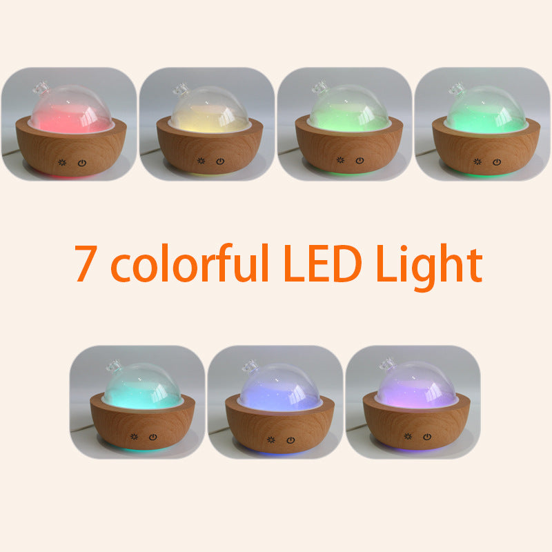 Aroma diffuser with light wood grain base and glowing multicolor LED light