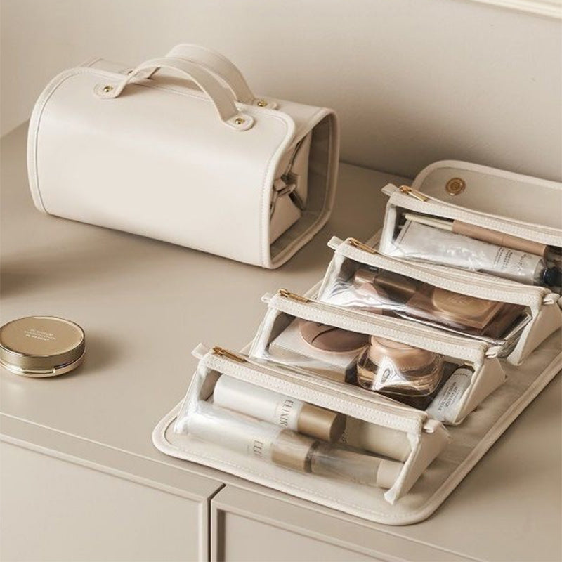 Light beige folding vanity bag opened to show clear organizer pouches and elastic dividers.
