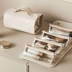 Light beige folding vanity bag opened to show clear organizer pouches and elastic dividers.