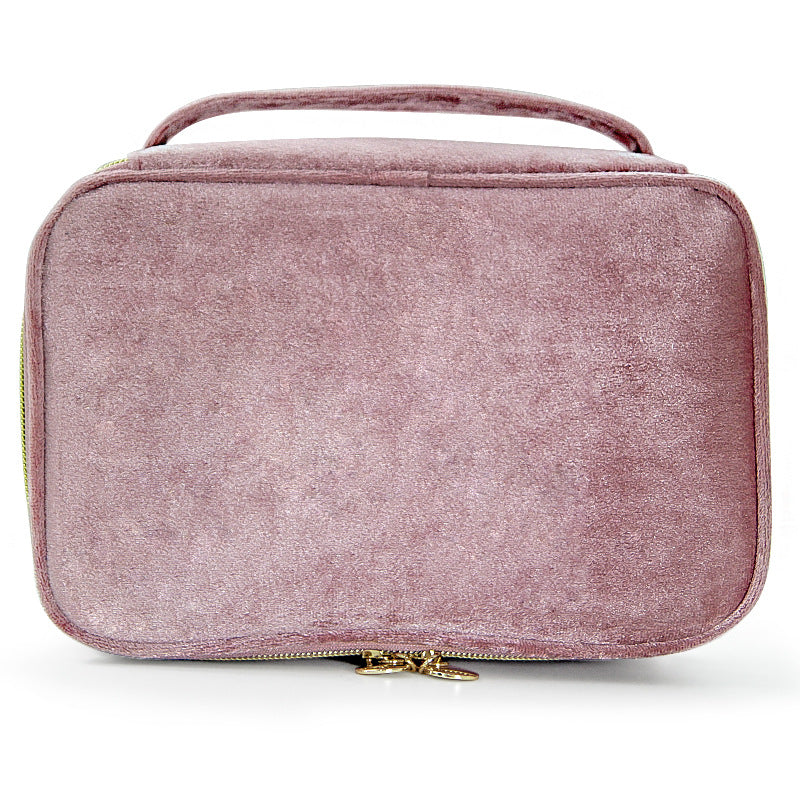 Soft travel cosmetic case in light pink with top handle and gold zipper pull