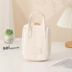 White shell travel vanity bag with top handle and decorative clasp