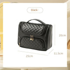 Midnight black vanity bag with quilted lid and front zip pouch, gold-tone zipper pulls